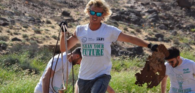 Varios voluntarios con camisetas de Ocean Initiatives recogen elementos contaminantes de una playa / Foto: Limpiaventura