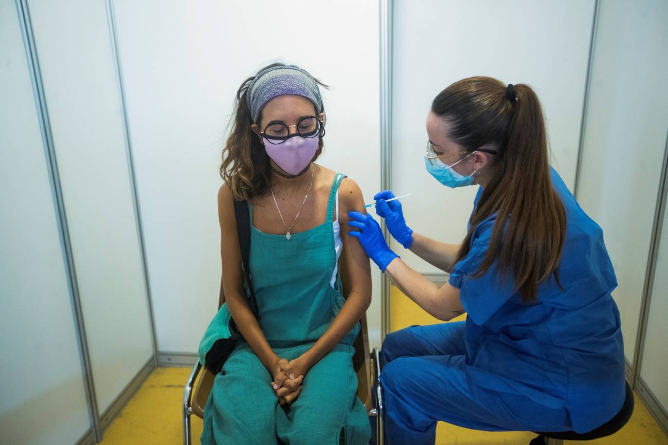 Una profesional sanitaria administra vacuna covid-19 a una joven en el centro de vacunación masiva instalado en la Fira de Cornellà (Barcelona). Contagios / Foto: SINC