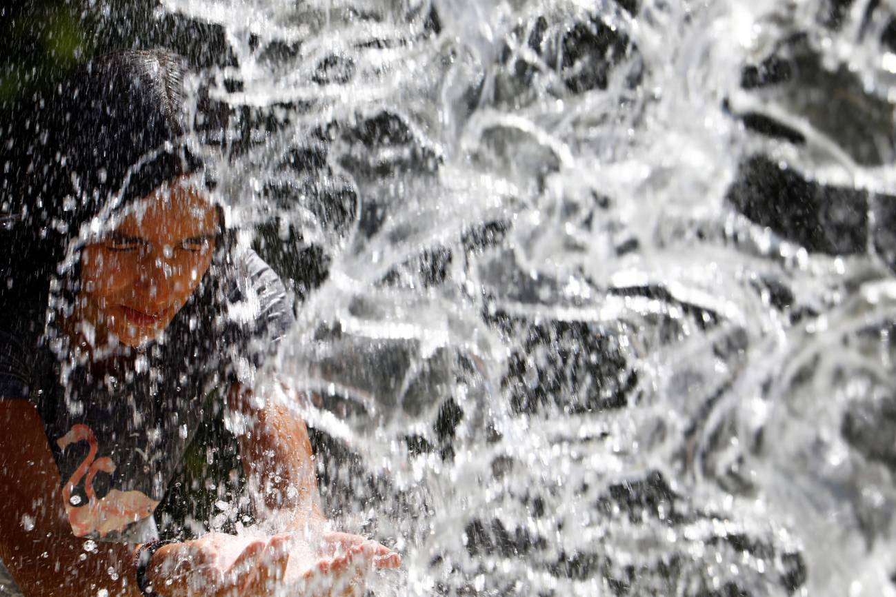 Una mujer se refresca en una fuente de Córdoba para intentar sofocar las altas temperaturas. Calor que mata / Foto: SINC