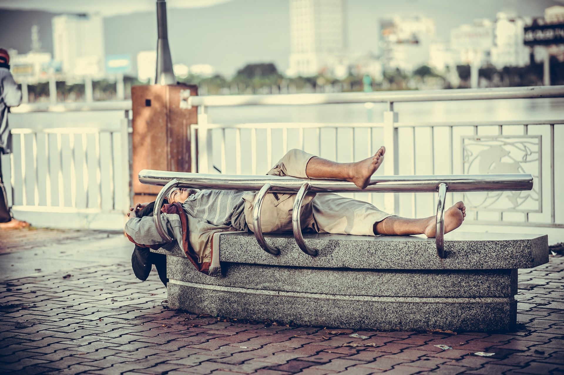 Un hombre duerme en un banco. Protección social / Foto: Pixabay