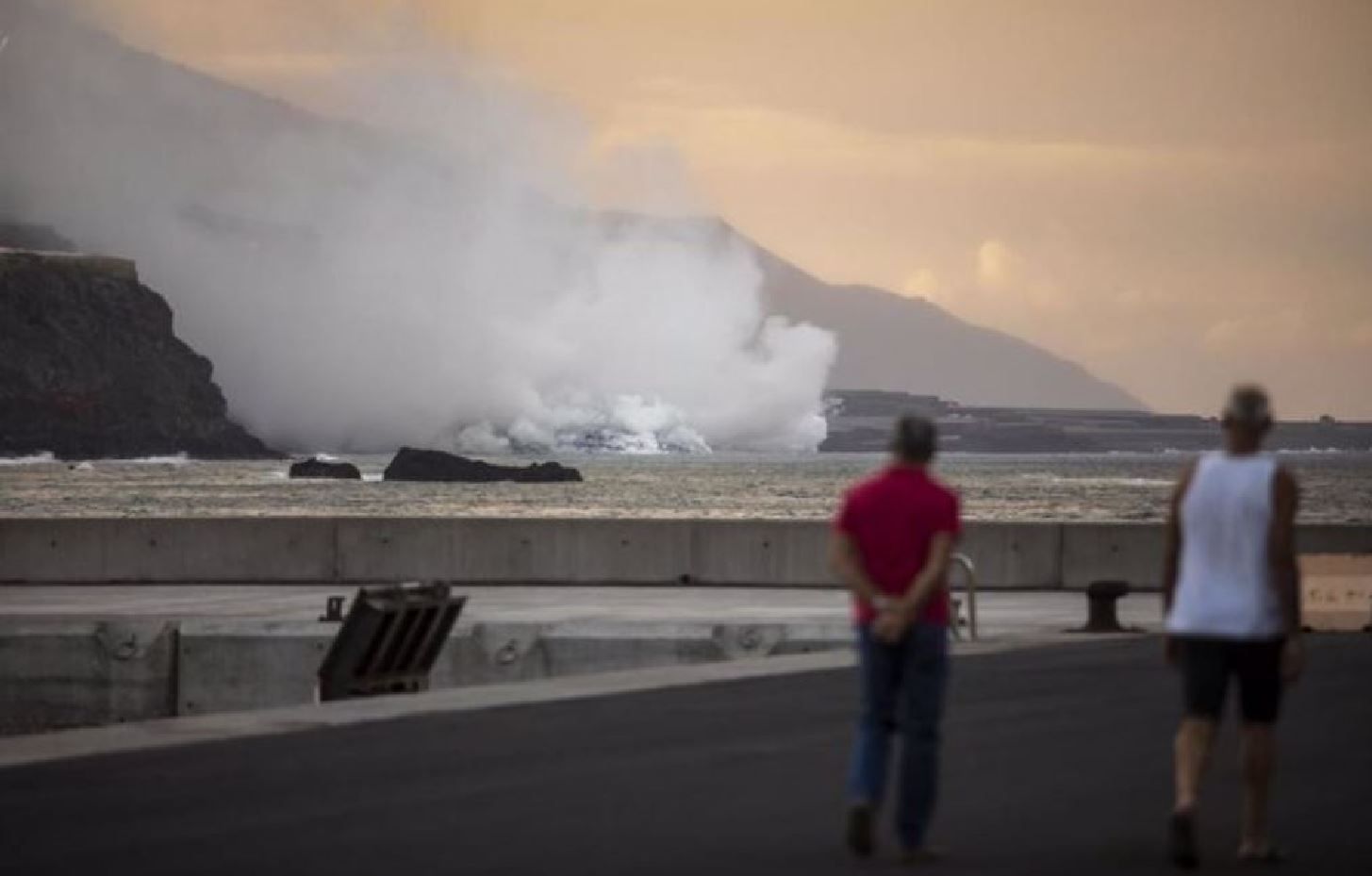 Dos personas observan la lava que llega al mar en La Palma genera una 'isla baja' que ya tiene más de medio kilómetro de ancho / Foto: Kike Rincón - EP