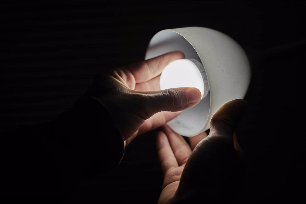 Una persona ajusta una bombilla eléctrica de una lámpara. Precio de la luz / Foto: Jesús Hellín - EP