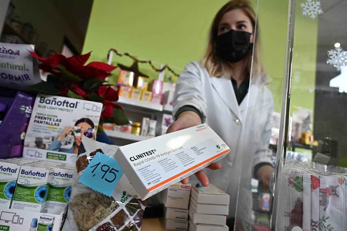 Una farmacéutica muestra el último test de antígenos que tiene disponible a la venta en su farmacia de Madrid / Foto: SINC