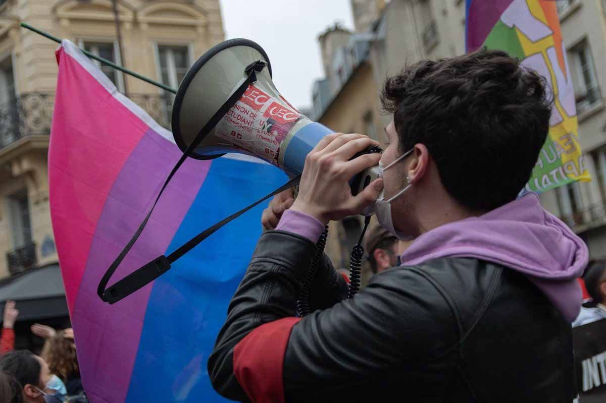 Un chico con un megáfono y una bandera LGTBI durante la manifestación en contra de la ultraderecha y la LGTBIFOBIA en París (Francia), a 31 de enero de 2021