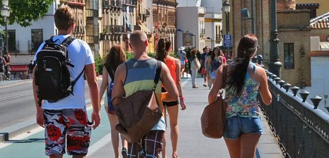 Turistas cruzando un puente sobre el Guadalquivir en Sevilla / Foto: EA