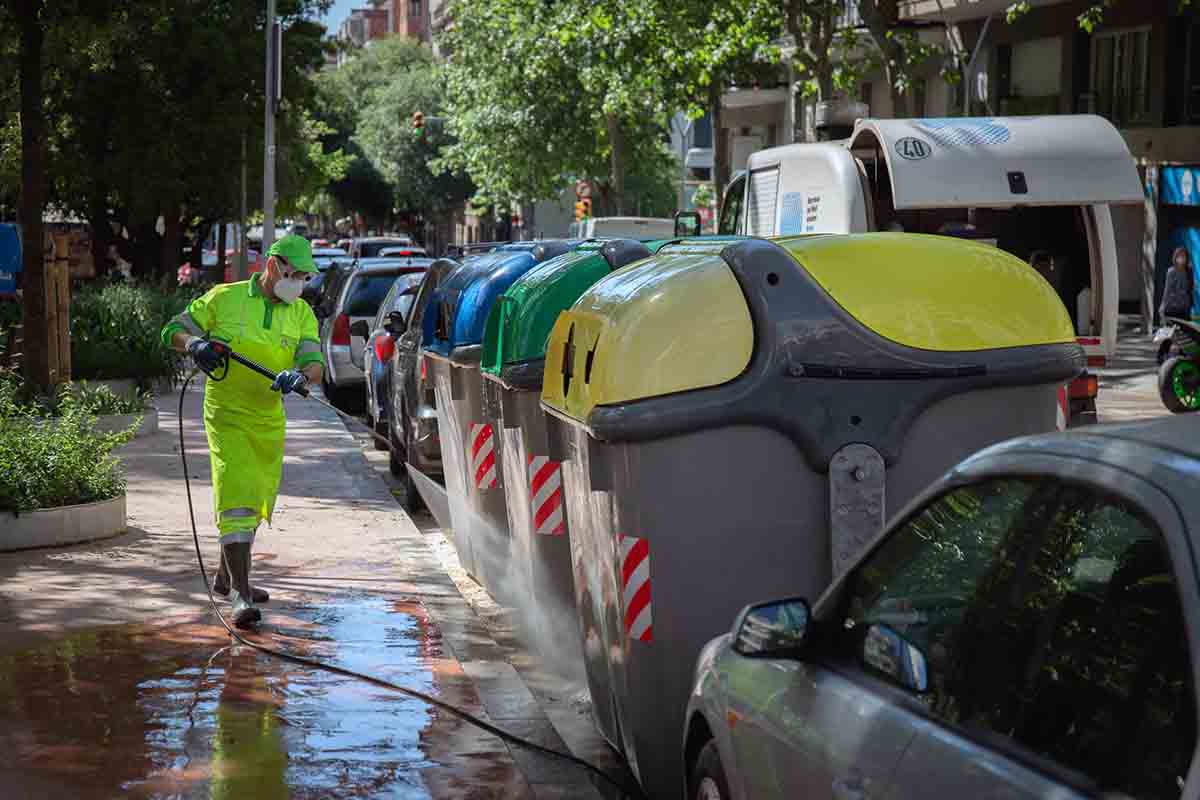 Un operario de limpieza del servicio municipal desinfecta un contenedor amarillo de residuos / Foto: Archivo - EP