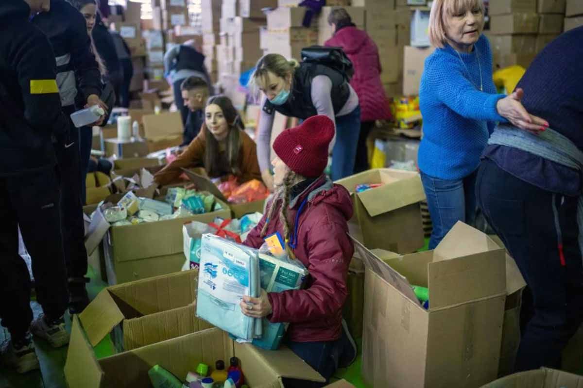 Varias voluntarios organizan las cajas de ayuda humanitaria en un pabellón cerca de la frontera entre Polonia y Ucrania / Foto: EP