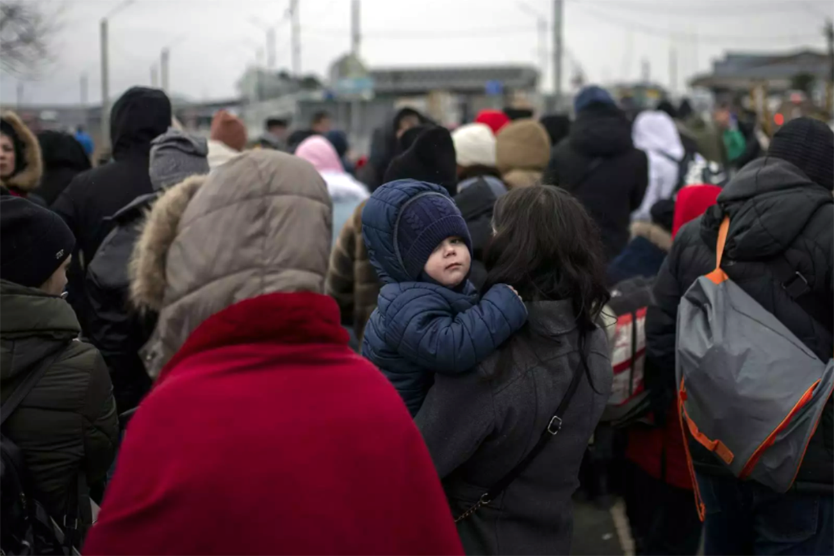 Varias personas y niños, esperan para cruzar a Rumanía, en el paso fronterizo de Porubne, a 5 de marzo de 2022, en el oeste de Ucrania. Rusia bombardea varias instalaciones médicas en Mariúpol / Foto: EP