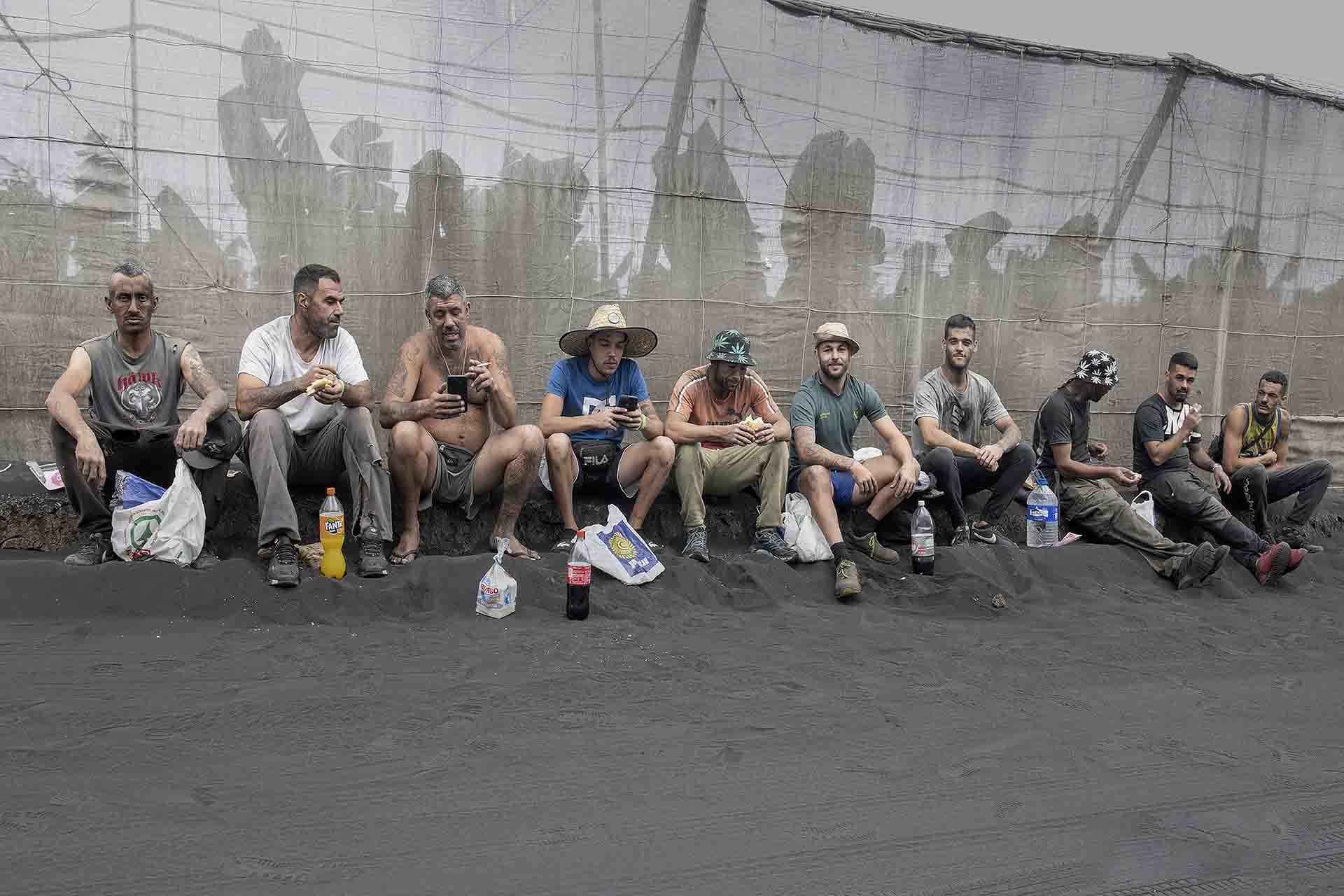 Un grupo de trabajadores comen y descansan durante una dura jornada de retirada de cenizas en los invernaderos en Isla de La Palma (Canarias) / Foto: Saul Santos