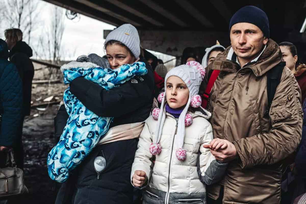 Varias personas con niños esperan para cruzar el río de Irpin, a 5 de marzo de 2022, en Irpin (Ucrania)