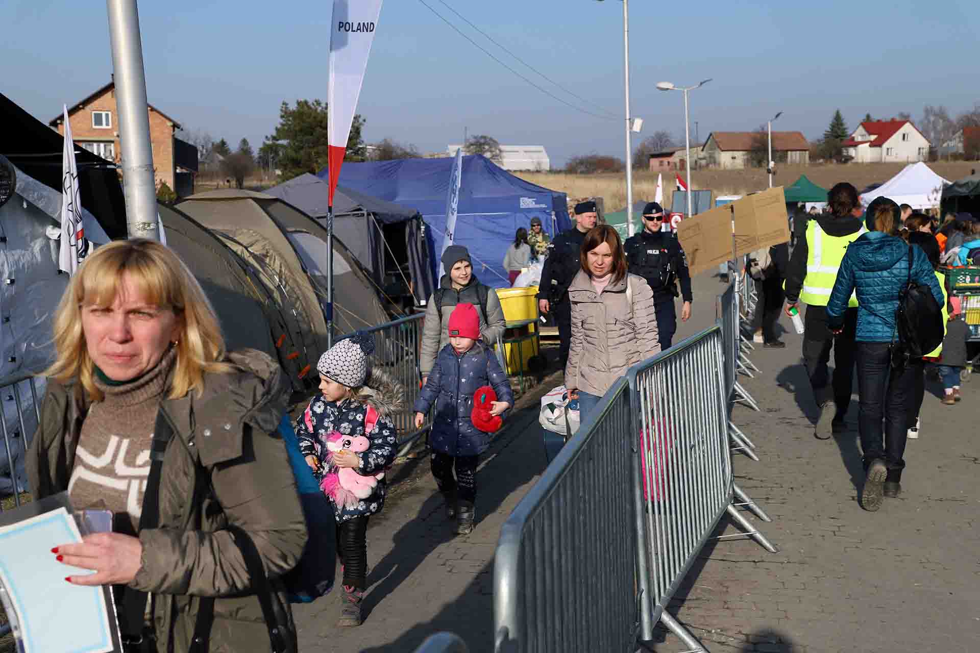 Un gupo de personas refugiadas de Ucrania cruza el paso repleto de carpas y tiendas en Medyka, Polonia / Foto: FFM - EA