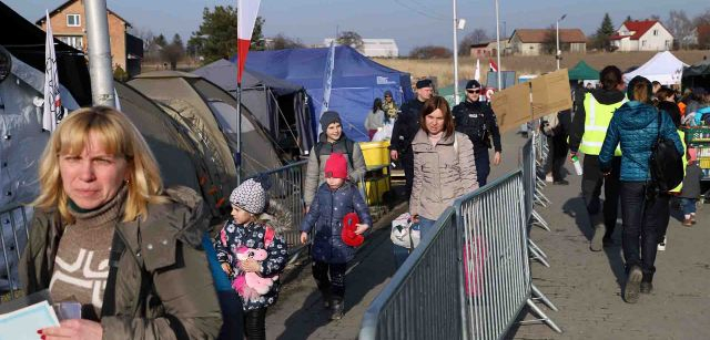Un gupo de personas refugiadas de Ucrania cruza el paso repleto de carpas y tiendas en Medyka, Polonia / Foto: FFM - EA