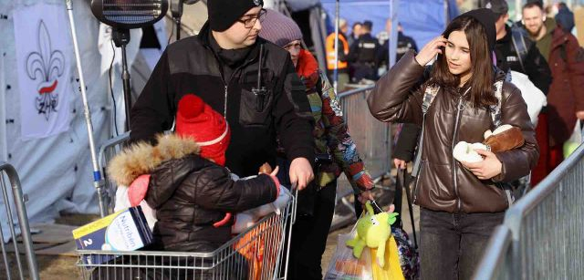 Una familia de personas refugiadas ucranianas cruza un paso repleto de carpas y tiendas en Medyka, Polonia / Foto: FFM - EA