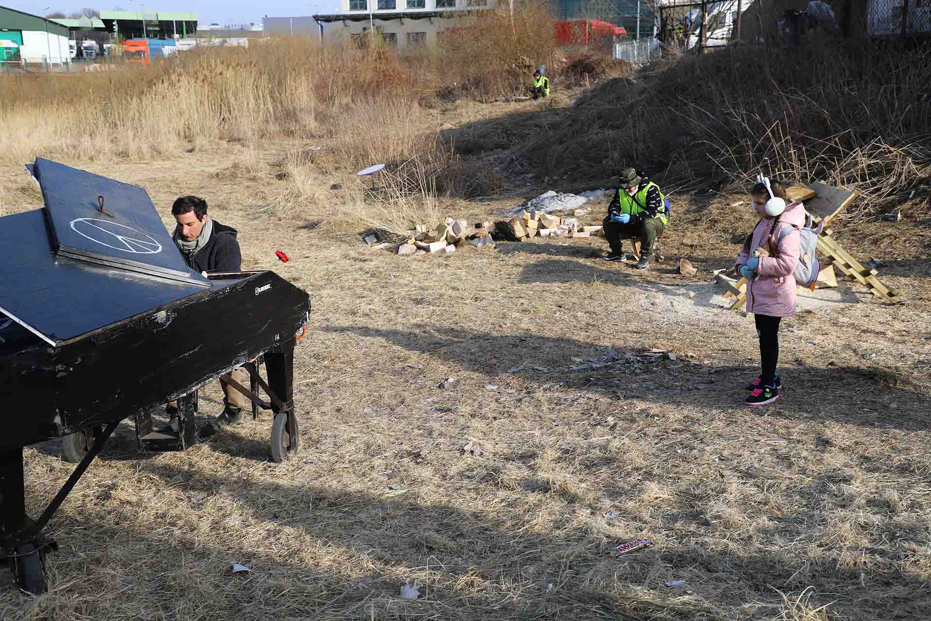 Una persona toca el piano en el exterior junto al paso fronterizo de Medyka, en Polonia / Foto: FFM - EA