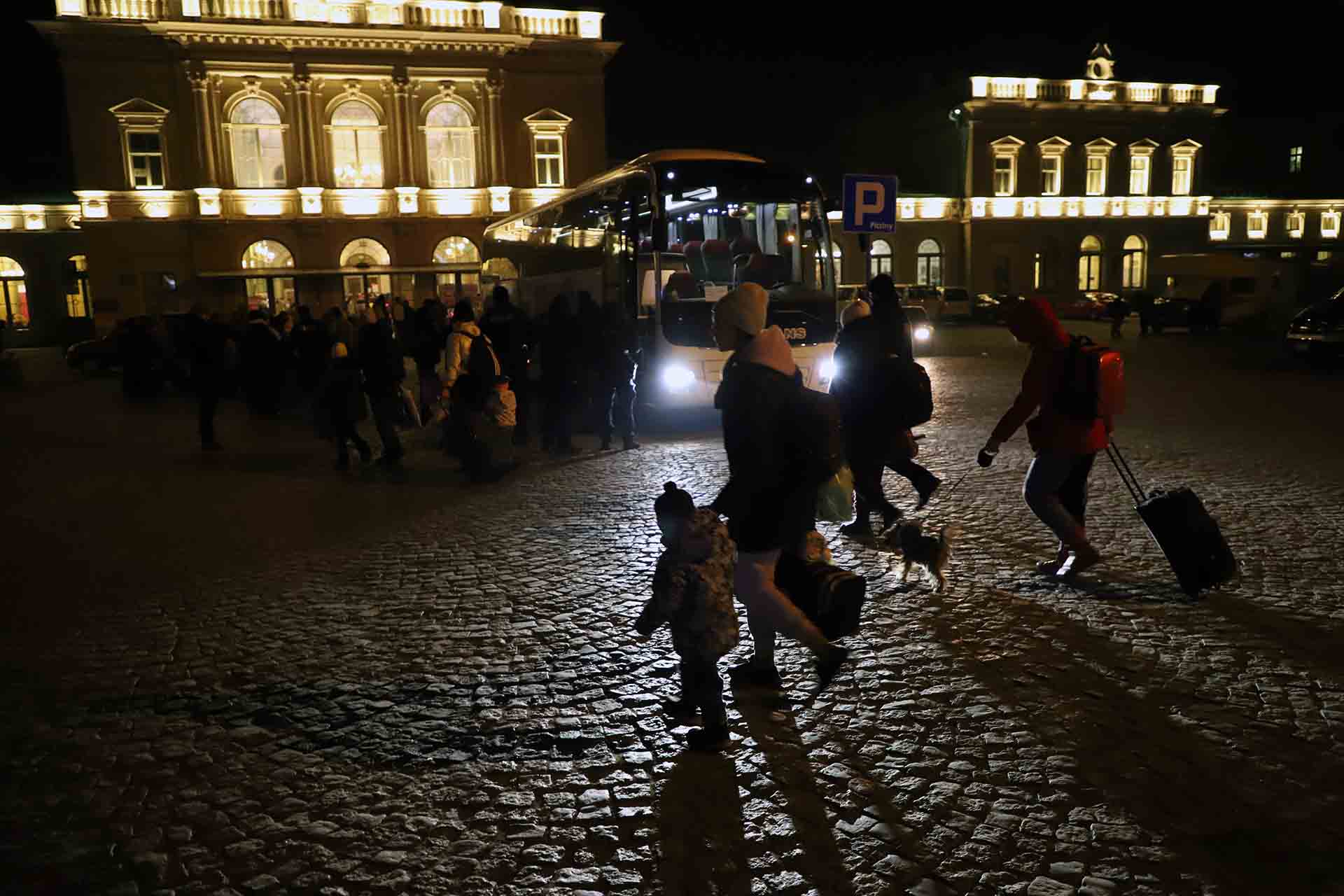 Grupa ukraińskich uchodźców przechodzi nocą przez plac przed stacją Przemyśl (Polska), aby wsiąść do autobusu jadącego do innego europejskiego miasta, aby uciec przed wojną na Ukrainie / Zdjęcie: FFM - EA