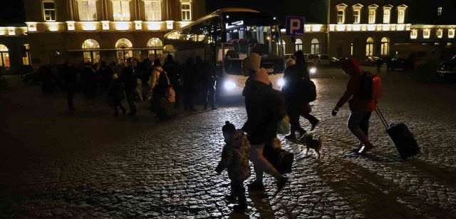 Un grupo de personas refugiadas ucranianas cruzan de noche la plaza de las afueras de la estación de Przemyśl (Polonia) para subir a un autobús con destino a otra ciudad europea para escapar de la guerra de Ucrania / Foto: FFM - EA