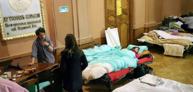 Una voluntaria responsable de la gestión del teatro habilitado para refugiados de Ucrania en Przemyśl (Polonia), conversa con una periodista de Antena 3, mientras una señora mayor duerme / FFM - EA