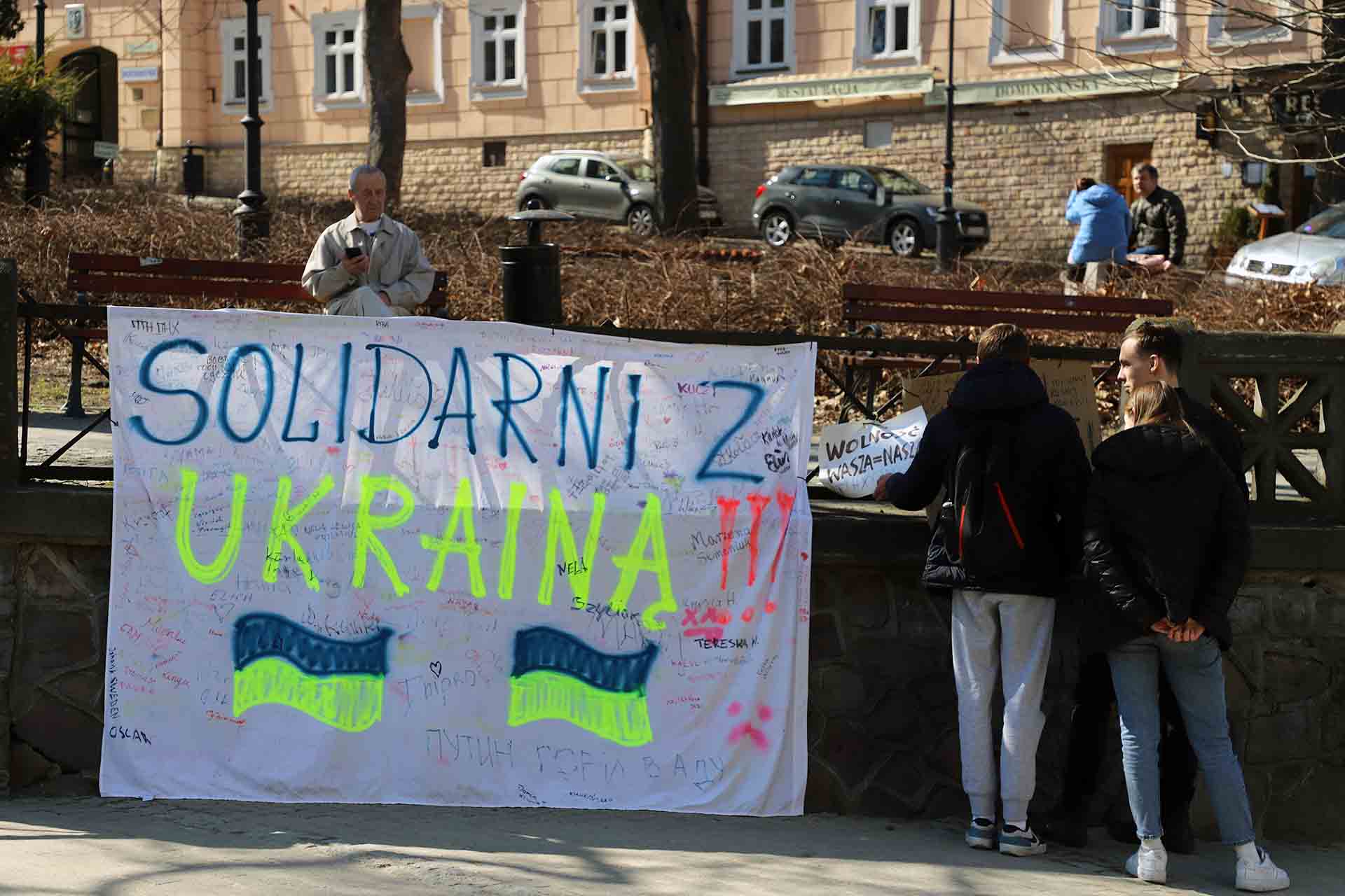 Unos jóvenes contemplan un lienzo en el que se puede leer ‘Solidaridad Ucrania’ en una de las plazas más céntricas de Przemyśl, Polonia / Foto: FFM - EA