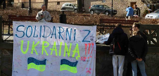 Unos jóvenes contemplan un lienzo en el que se puede leer ‘Solidaridad Ucrania’ en una de las plazas más céntricas de Przemyśl, Polonia / Foto: FFM - EA