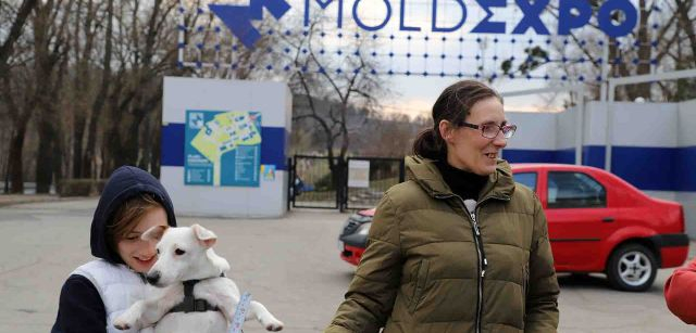 Un niño ucraniano con su mascota frente al MoldExpo, un centro de convenciones de Chisinau, capital de Moldavia / Foto: FFM - EA