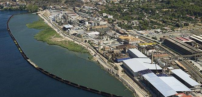 Vista aérea de la planta química de Ercros en Flix y la zona contaminada, aislada por un muro de protección / Foto: Acuamed