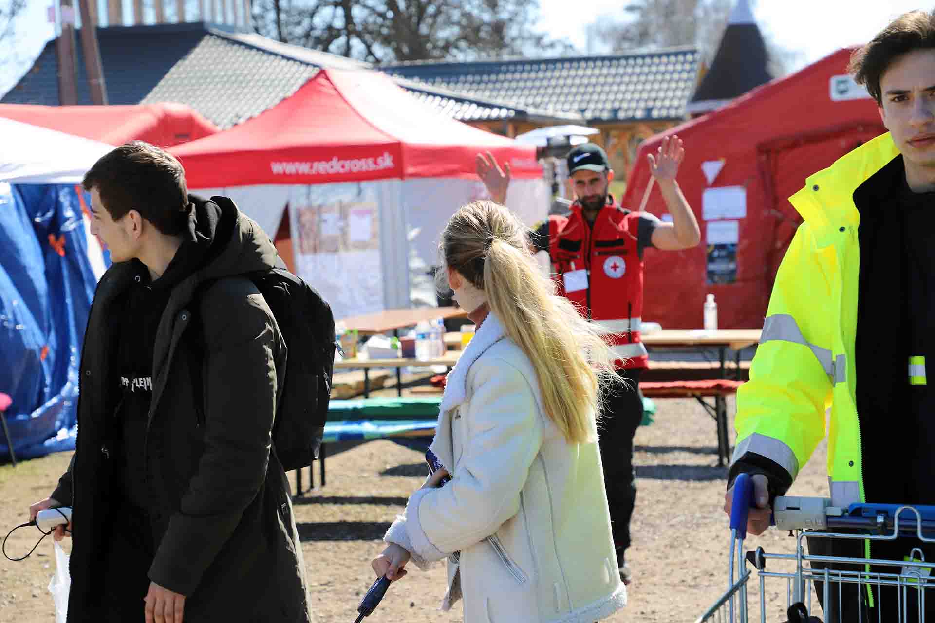 El voluntario de la Cruz Roja Eslovaca, Stanislav Zupka, se despide de los refugiados Sobia Gorentsobia (20 años) y Oleg Babenko (15 años) ante la llegada de su transporte / Foto: FFM - EA