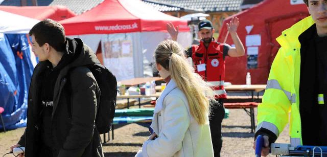 El voluntario de la Cruz Roja Eslovaca, Stanislav Zupka, se despide de los refugiados Sobia Gorentsobia (20 años) y Oleg Babenko (15 años) ante la llegada de su transporte / Foto: FFM - EA