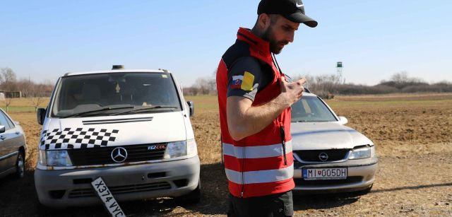 El voluntario de la Cruz Roja Eslovaca, Stanislav Zupka, habla por radio junto a una furgoneta venida de Ucrania en un estado defectuoso, con una torre de vigilancia de la frontera con Ucrania / Foto: FFM - EA