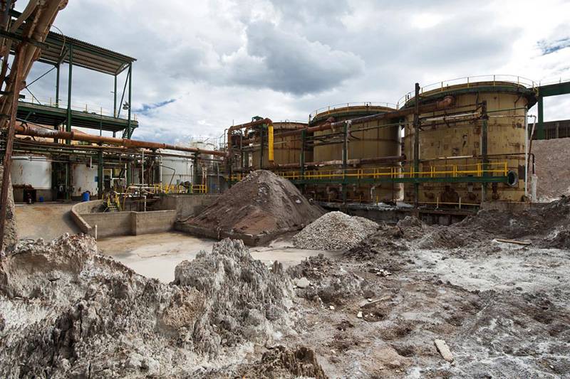 Residuos procedentes de la actividad de la fábrica amontonados junto a unos depósitos decrépitos / Foto: Josep Cano