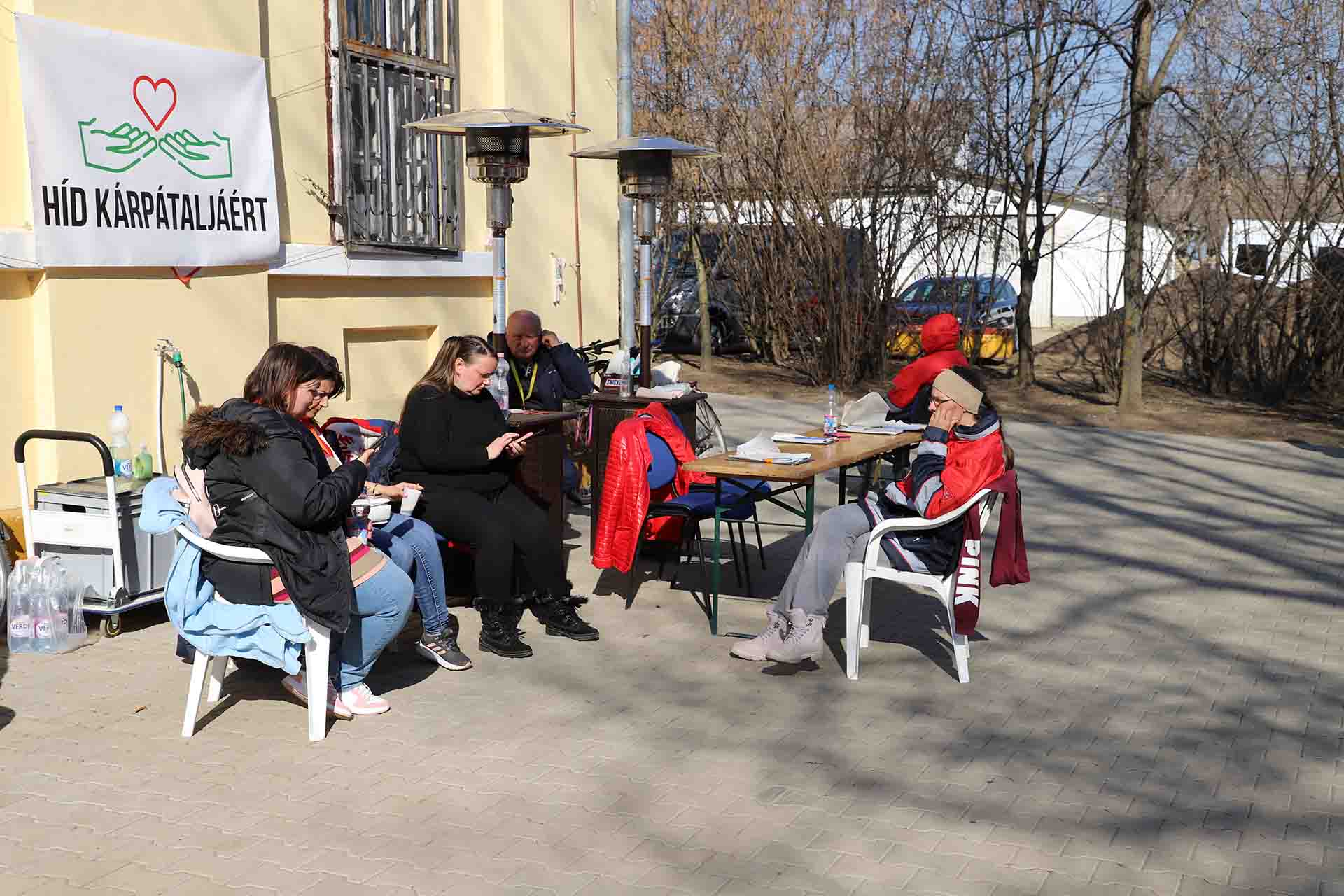 Un grupo de personas refugiadas descansan en el exterior del centro asistencia de Beregsurány (Hungría) / Foto: FFM - EA