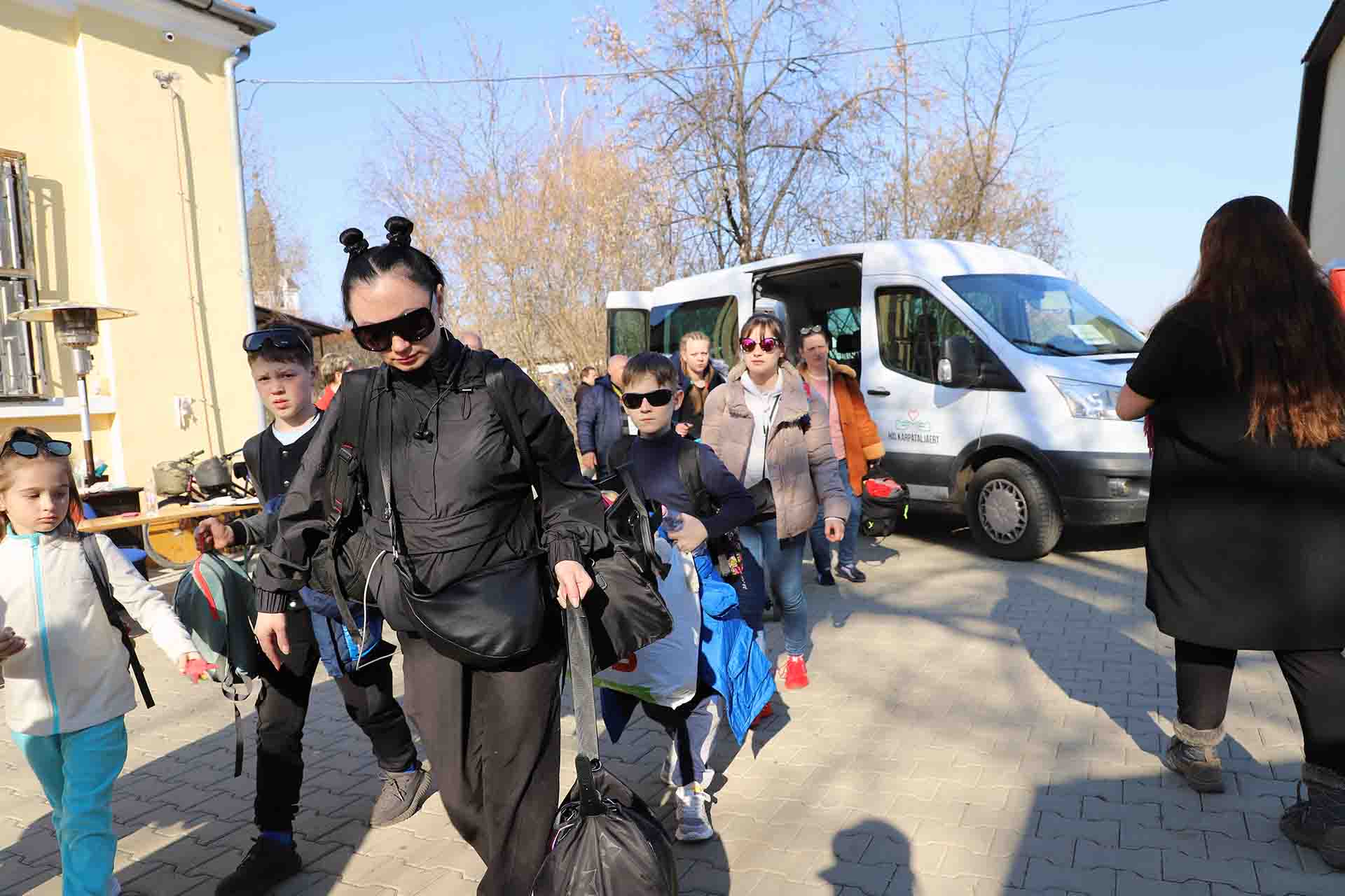 Un grupo de refugiados bajan de una furgoneta autobús que viene de Ucrania a Beregsurány (Hungría) / Foto: FFM - EA