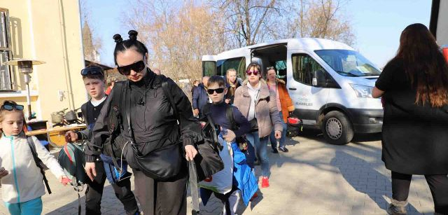 Un grupo de refugiados bajan de una furgoneta autobús que viene de Ucrania a Beregsurány (Hungría) / Foto: FFM - EA