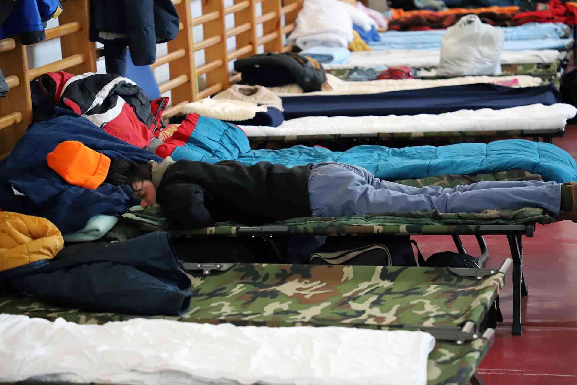 Un joven ucraniano entre otros refugiados descansa exhausto en el gimnasio habilitado para ello en a Beregsurány (Hungría) / Foto: FFM - EA