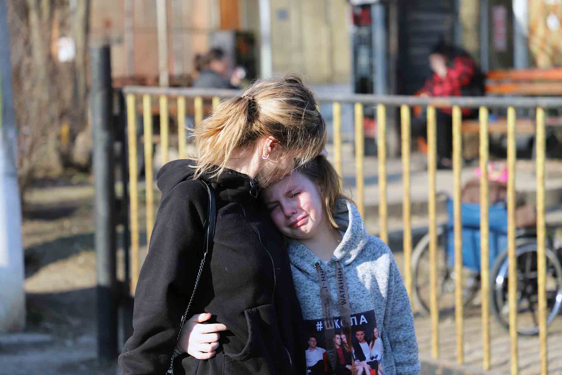 Una madre consuela a una niña ucraniana el momento en que se separa de sus dos hermanos que parten para Palencia, en España / Foto: FFM - EA