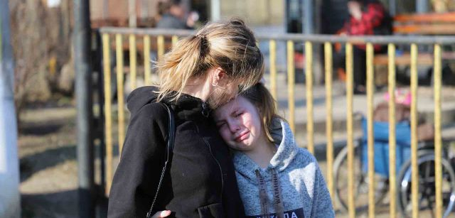 Una madre consuela a una niña ucraniana el momento en que se separa de sus dos hermanos que parten para Palencia, en España / Foto: FFM - EA