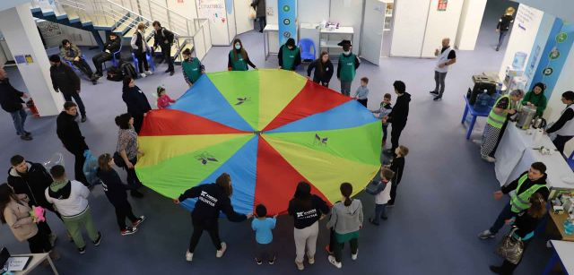 Un grupo de niñas y niños ucranianas hacen un circulo en el interior de uno de los pabellones de MoldExpo, en Chisináu (Moldavia)  / Foto: FFM - EA