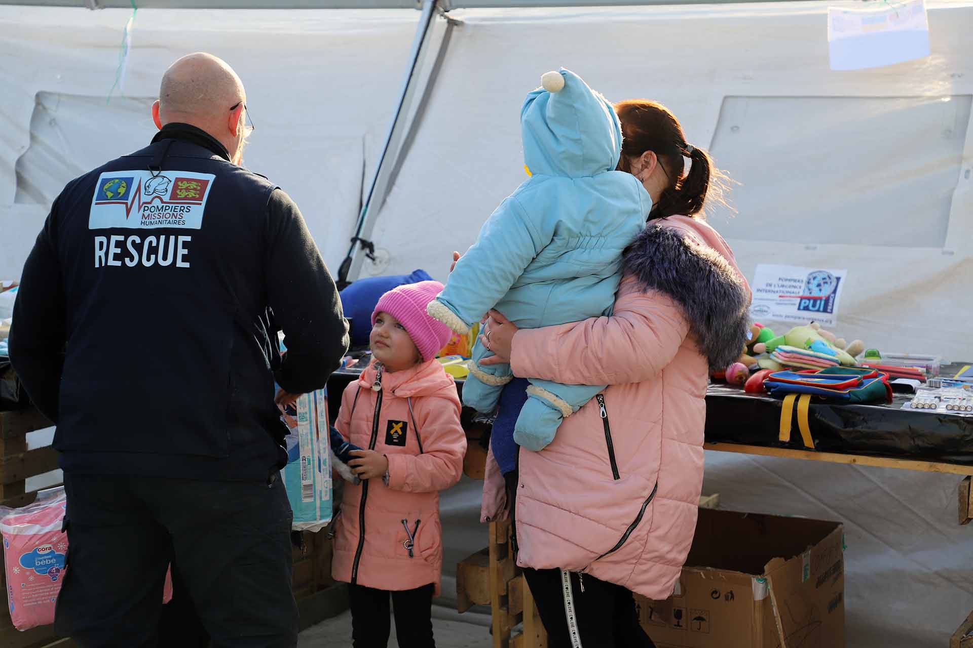 Un bombero atiende a una niña ucraniana en Palanca, la frontera de Moldavia con Ucrania / Foto: FFM - EA