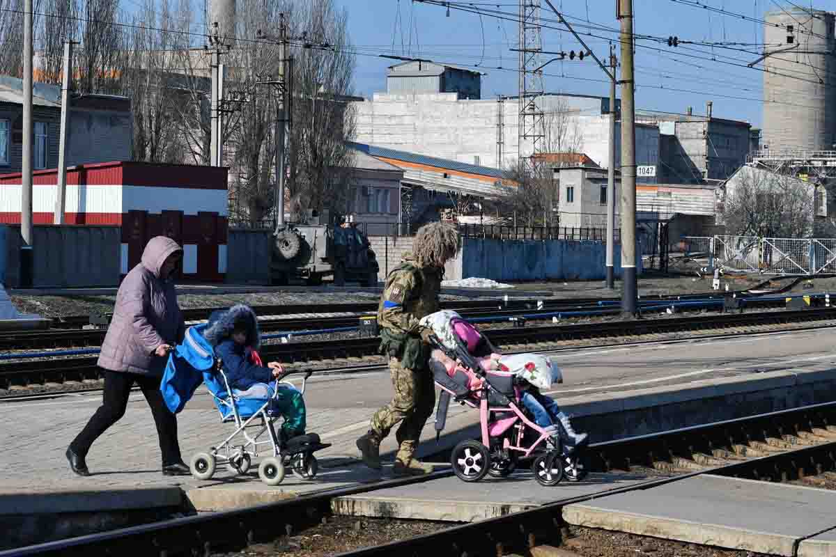 Una mujer y un militar son vistos ayudando a varios niños a subirse a un tren en Ucrania en el marco de la invasión rusa / Foto: Archivo - EP