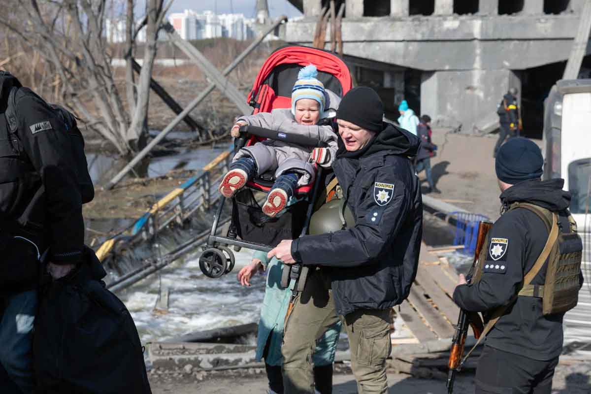 Un militar de Ucrania lleva a un niño durante la evacuación de civiles en la ciudad de Irpin / Foto: Archivo - EP