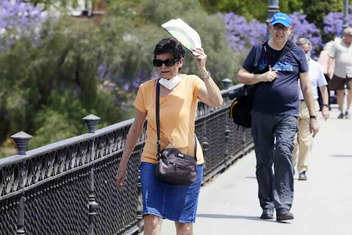 Una señora se protege del Sol con un abanico durante el primer día de altas temperaturas en Sevilla, a 19 de mayo de 2022 en Sevilla (Andalucía, España) / Foto: EP