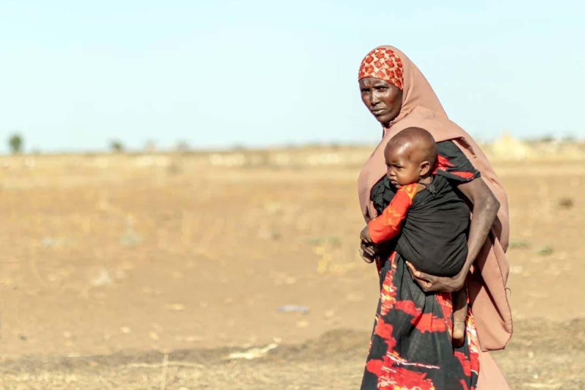 Una madre carga a su hijo a través del reseco paisaje de la región somalí de Etiopía. La migración en el mundo / Foto: Eugene Sibomana - ACNUR
