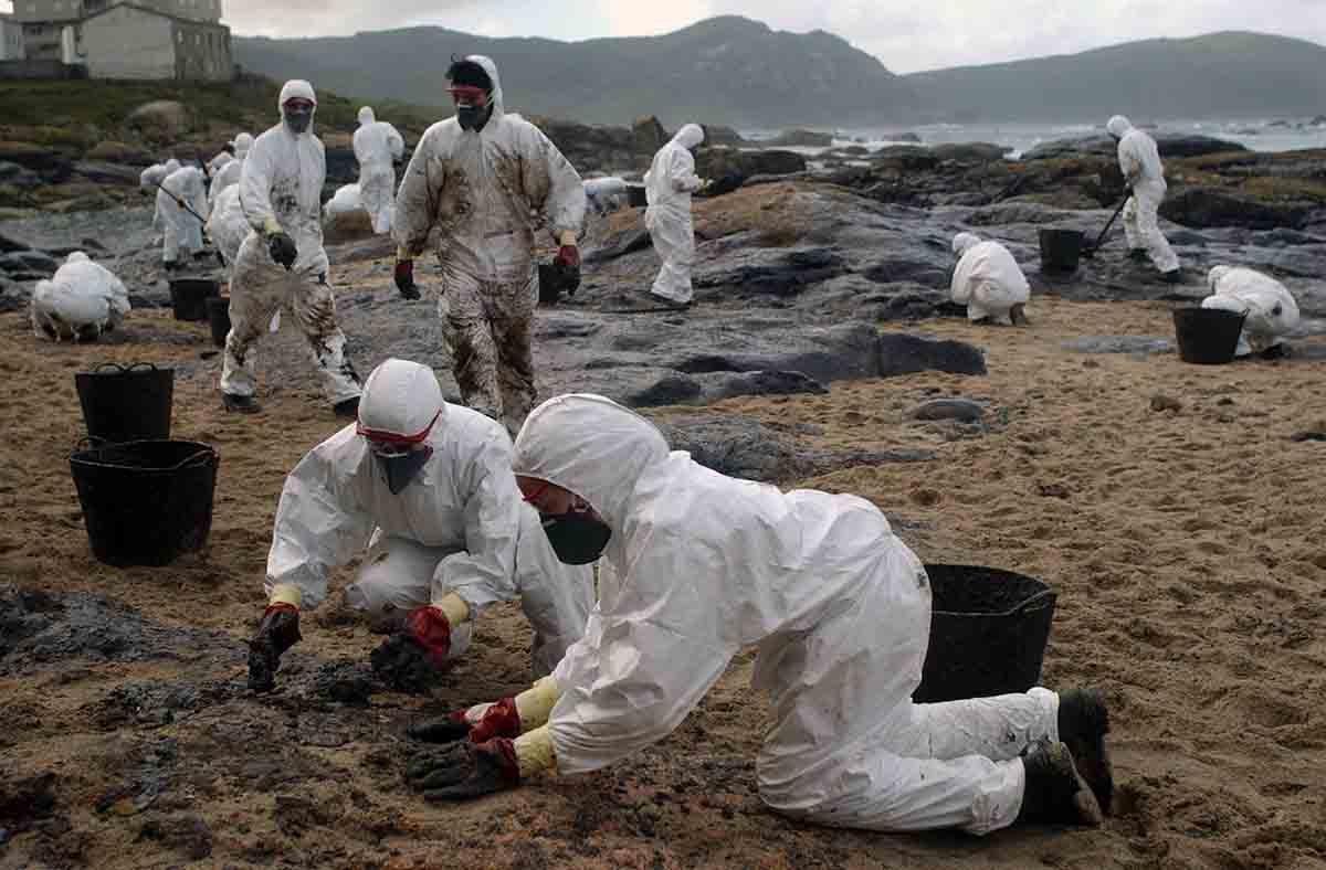 Costas y playas coruñesas bañadas por vertido de fuel que derramó el Prestige, voluntarios ayundando a limpiar el vertido / Foto: EP