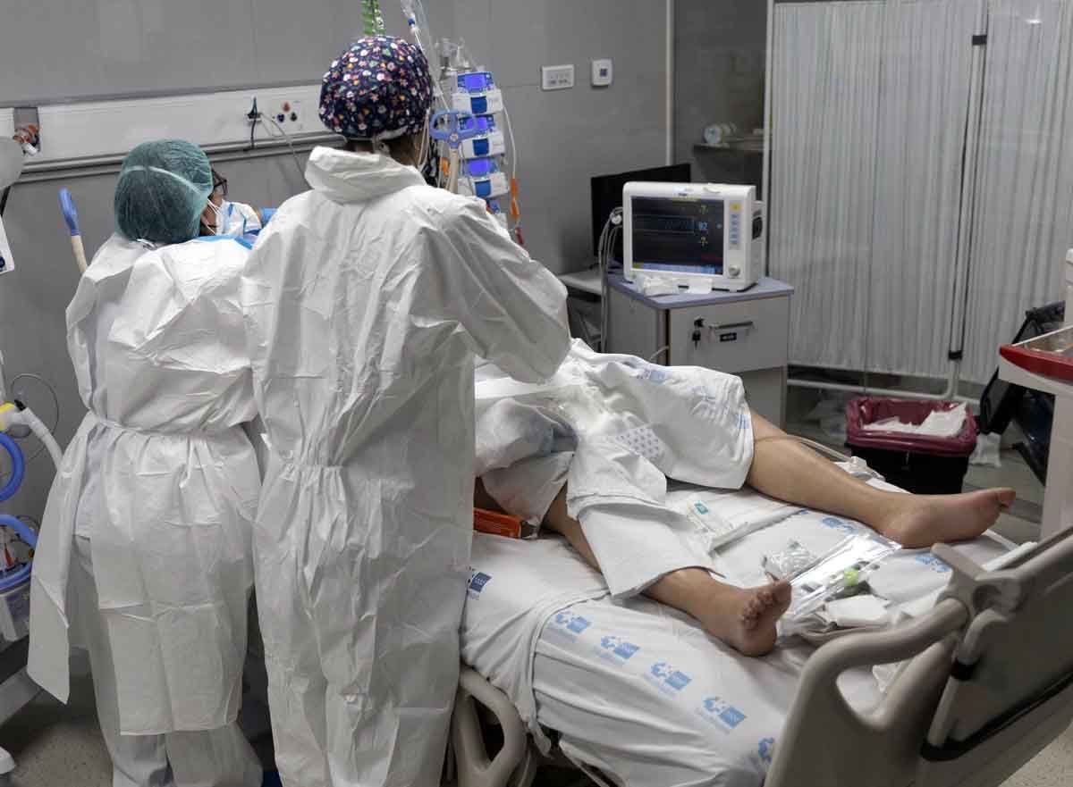 Dos sanitarios atienden a un paciente Covid / Foto: EP