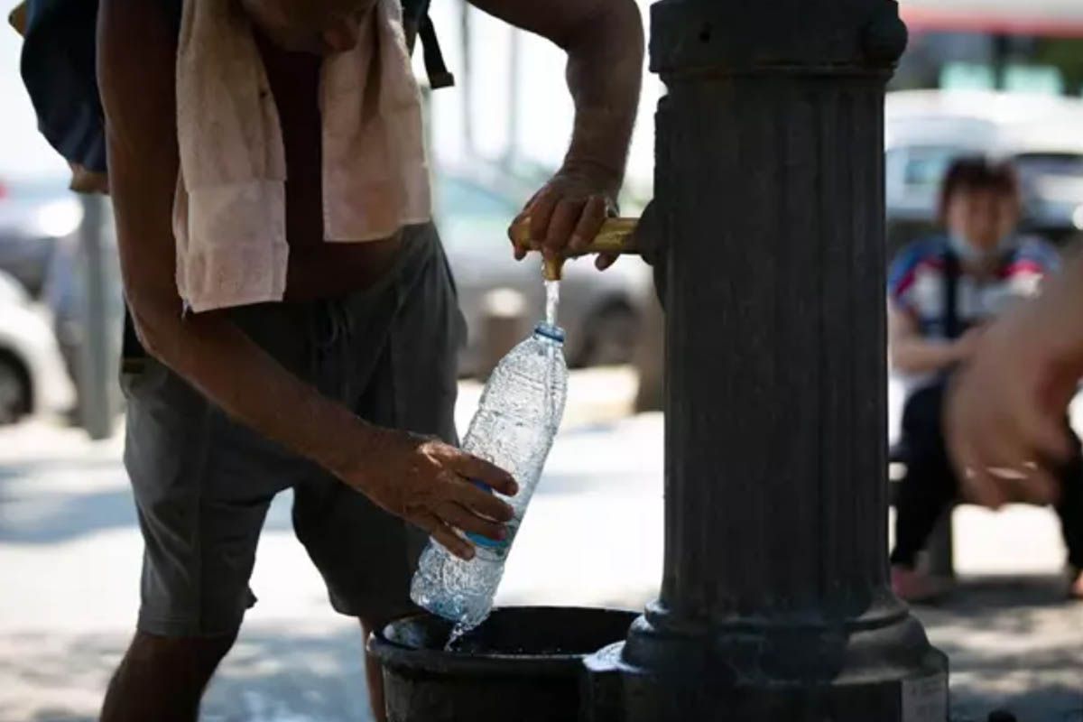 Un hombre rellena una botella de agua en una fuente en el parque de la Barceloneta, a 13 de julio de 2022, en Barcelona. Ola de calor / Foto: EP