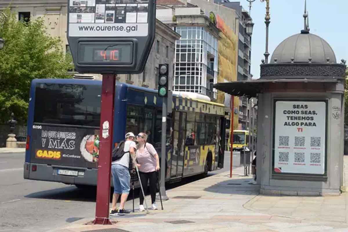 Dos personas se saludan al lado de un termómetro en la calle que marca 41 grados, a 12 de julio de 2022, en Orense, Galicia (España) / Foto: EP