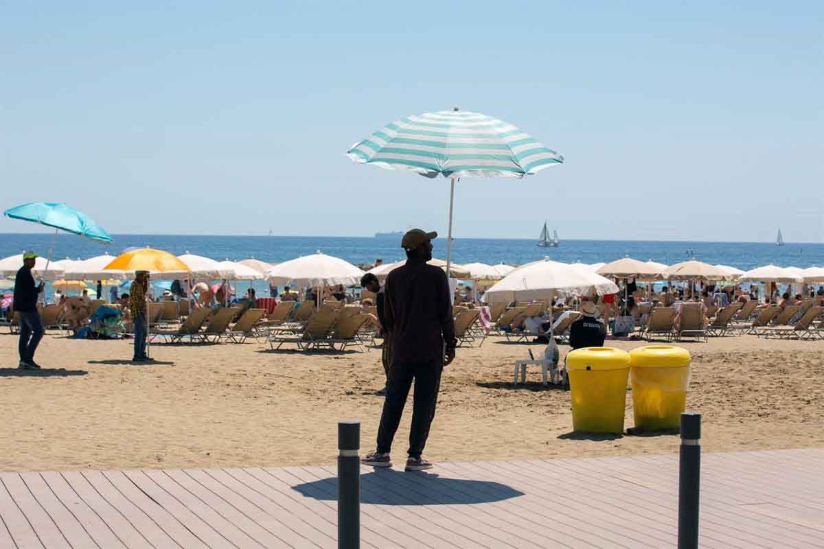 Varias personas se protegen del sol en la playa de la Barceloneta, a 13 de julio de 2022, en Barcelona, Catalunya (España). Ola de calor / Foto: EP