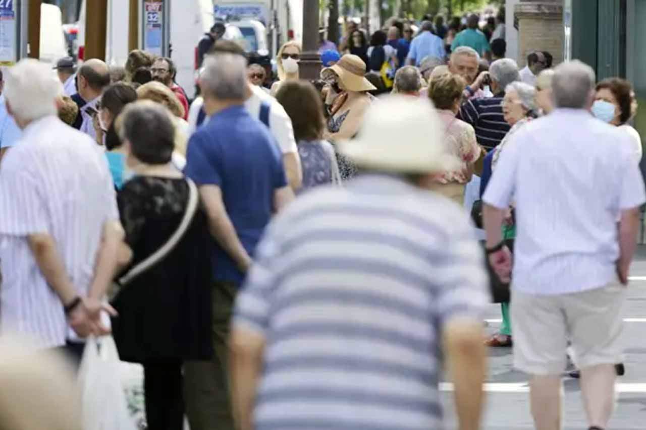 Una multitud de personas pasean por una avenida con mascarillas para protegerse de la infección contra el coronavirus / Foto: EP