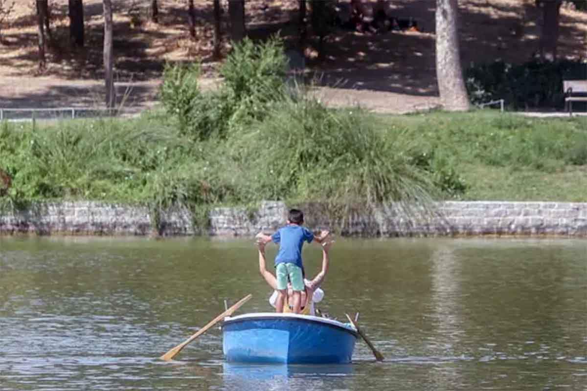 Un niño juega con otra persona en una barca alquilada del lago de la Casa de Campo, a 21 de agosto de 2022, en Madrid (España). Calor / Foto: EP