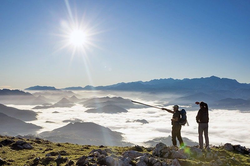 Un guarda de la reserva del Sueve (Asturias) señala el valle del río Sella cubierto por la niebla con los Picos de Europa al fondo / Foto: Roger Rovira