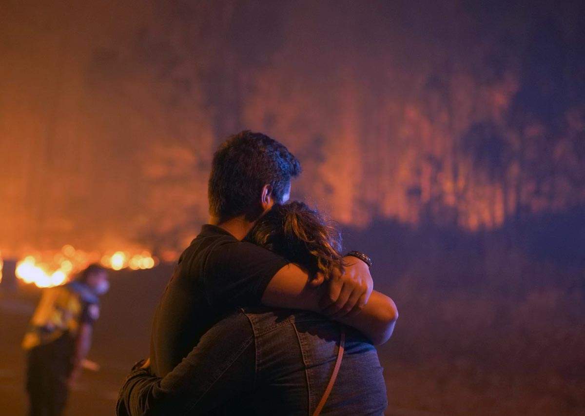 Dos personas se abraza en las inmediaciones del incendio, a 5 agosto de 2022, en O Vento, parroquia de Cea, en la comarca de Salnes y el concello de Villagarcía de Arousa, Pontevedra, Galicia (España) / Foto: EP